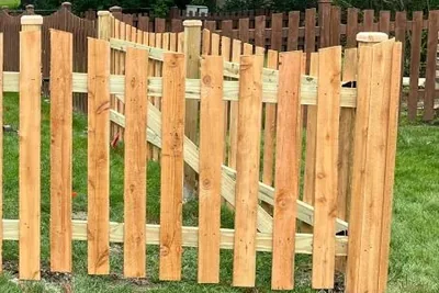 Spaced cedar picket fence turning a corner in a residential yard